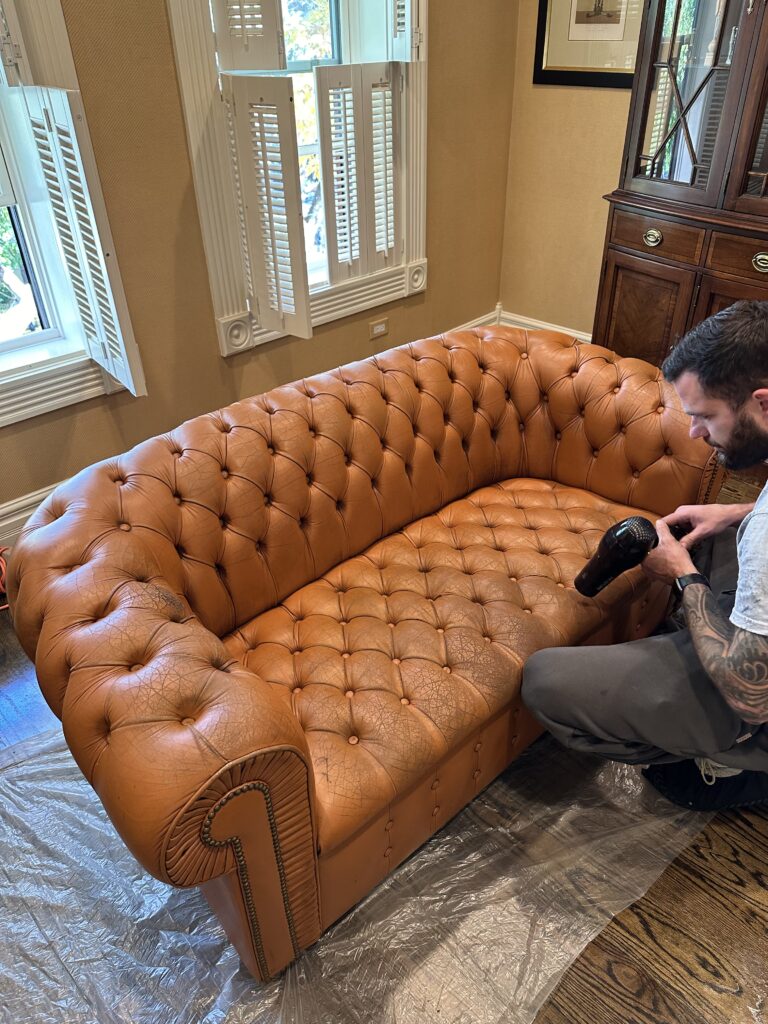 Worn Chesterfield sofa before restoration