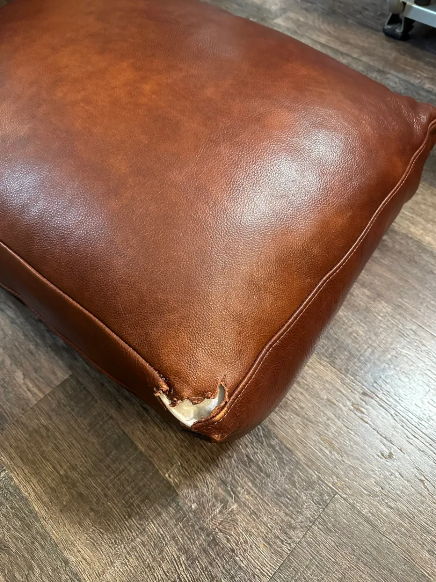 Cushion torn by a dog: new leather sewn, color matched (before)