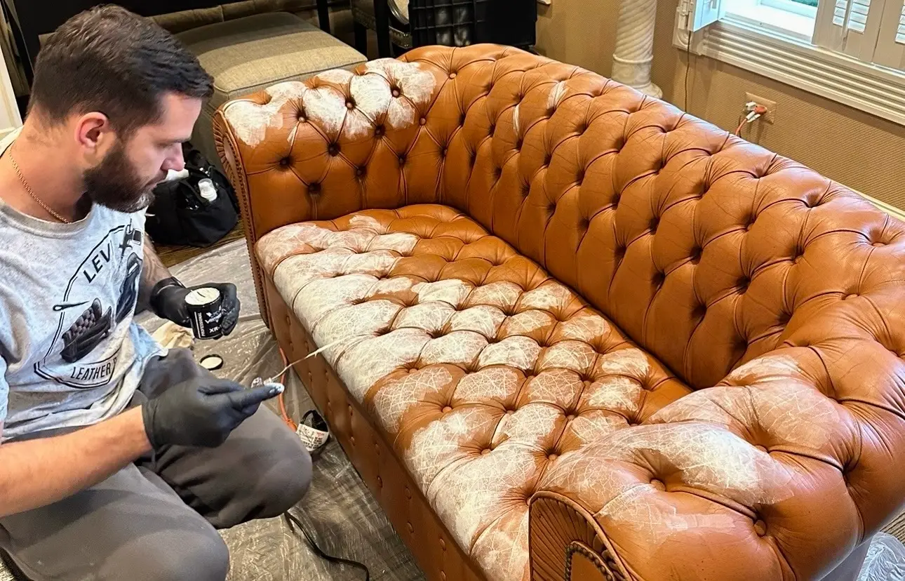 Artem restoring a leather Chesterfield sofa