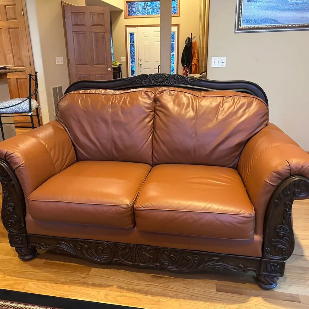 Leather loveseat: body oil removed where heads rest on the back, color restored in a new shade (after)